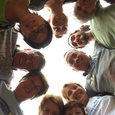 A group of older adults completing childcare volunteer work in Nepal, take a photo at their placement. A group of volunteers over 50 doing childcare volunteering in Nepal, take a photo outside their placement.